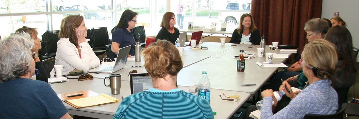 Group of adults sitting around a table during a book club meeting