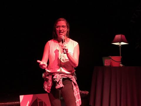 image of a person speaking into a microphone and making hand gestures