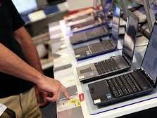 A person perusing a row of computers in a store