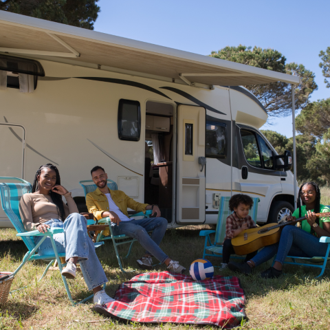 family picnicking outside their camper
