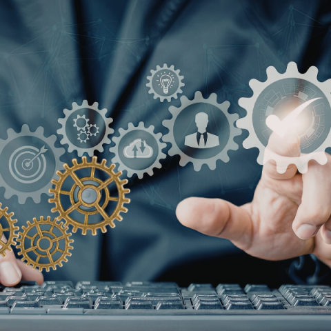 image of a person's hands typing on a keyboard with graphics of cogs floating above
