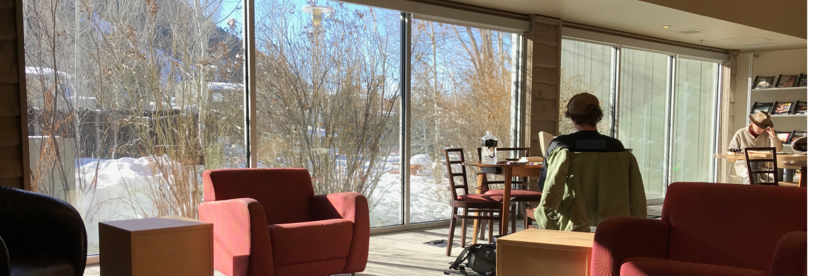 image of people sitting near the large window of the reading room with a view of the snowy outdoors